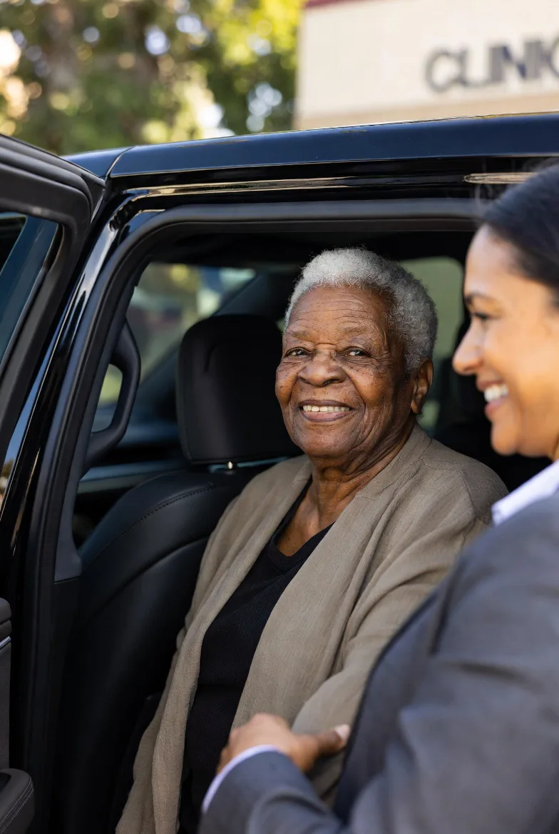 Companion assisting patient at vehicle door